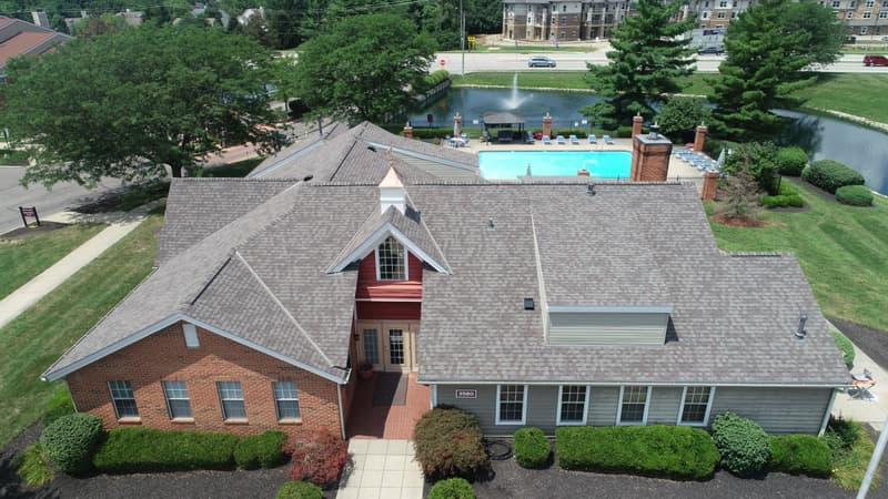 Aerial view of shingle roof on clubhouse beside pool